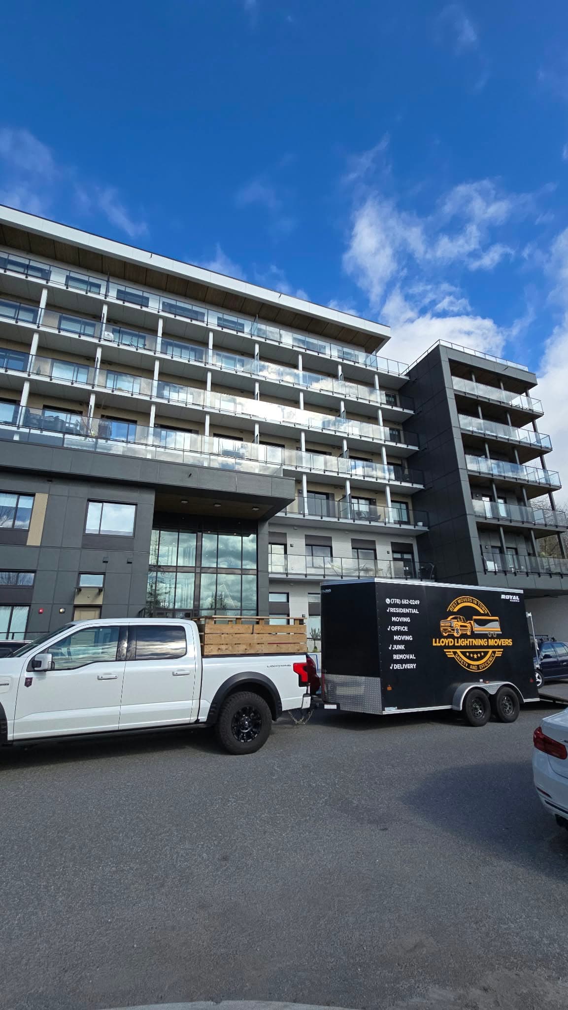 Lloyd Lightning Movers truck and branded trailer outside a condo building